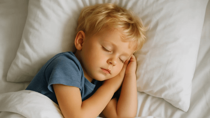 enfant blondinet qui dort dans son lit