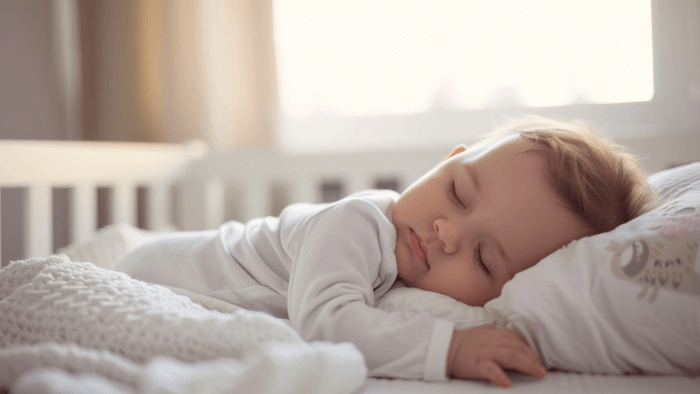 Bébé de 9 mois dormant paisiblement dans son lit après avoir surmonté la régression du sommeil