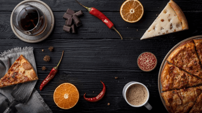 Chocolat noir, verre de vin, épices et fromage disposés sur table de nuit