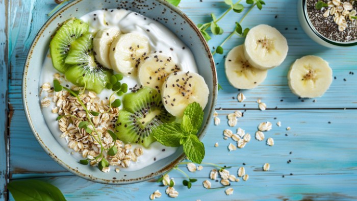 Bol de petit-déjeuner sain avec yaourt nature, flocons d'avoine, kiwi et banane pour éviter les ballonnements