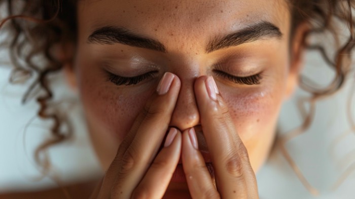 Femme pratiquant la technique de respiration pour déboucher son nez en retenant sa respiration