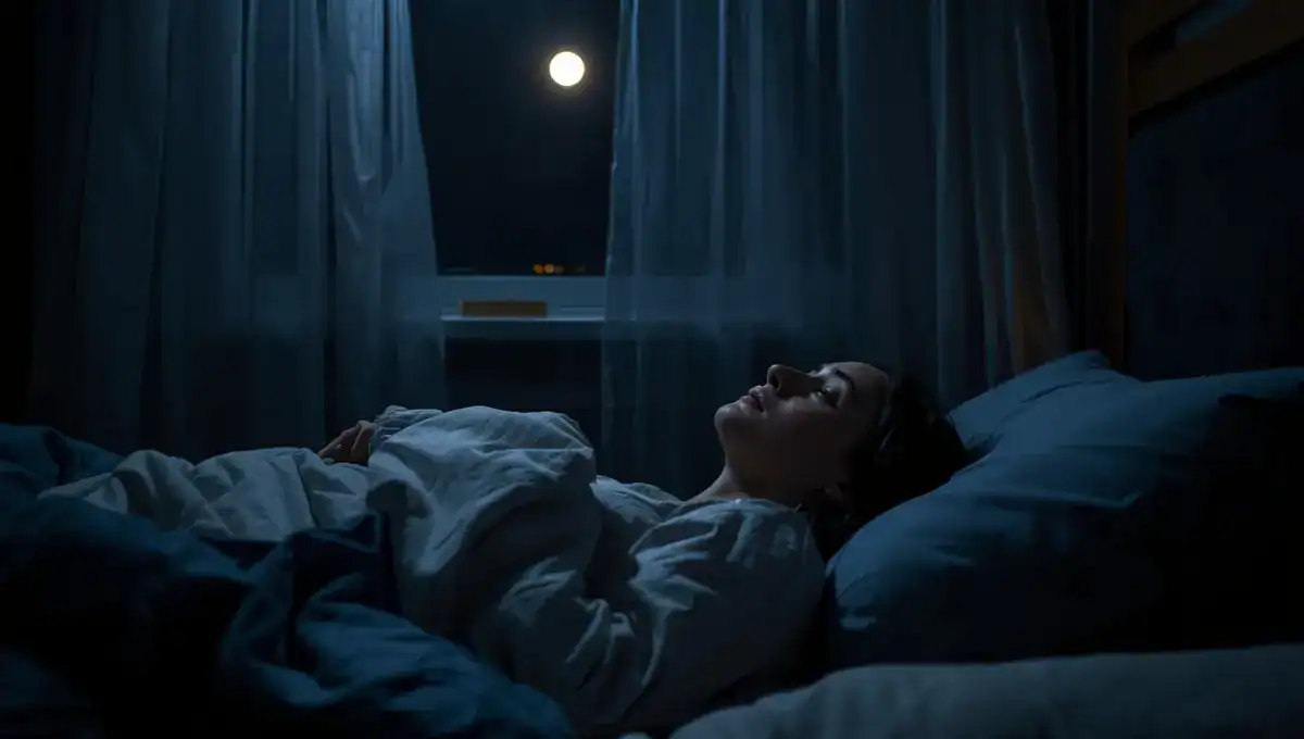 Femme allongée éveillée la nuit souffrant d'insomnie chronique, chambre baignée d'une lumière douce et tamisée